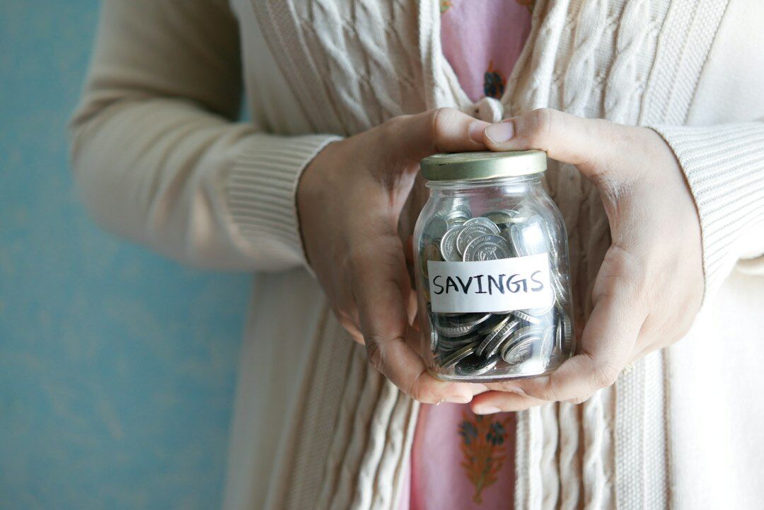 person saving coins in jar