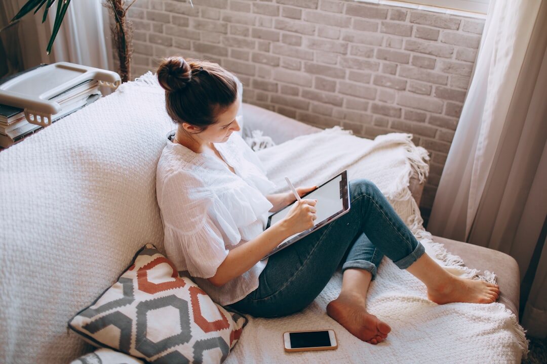 Woman taking an online finance course on a laptop while taking notes